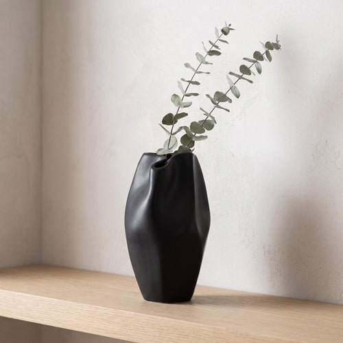 Alven vase on a pale oak shelf holding dried eucalyptus stems