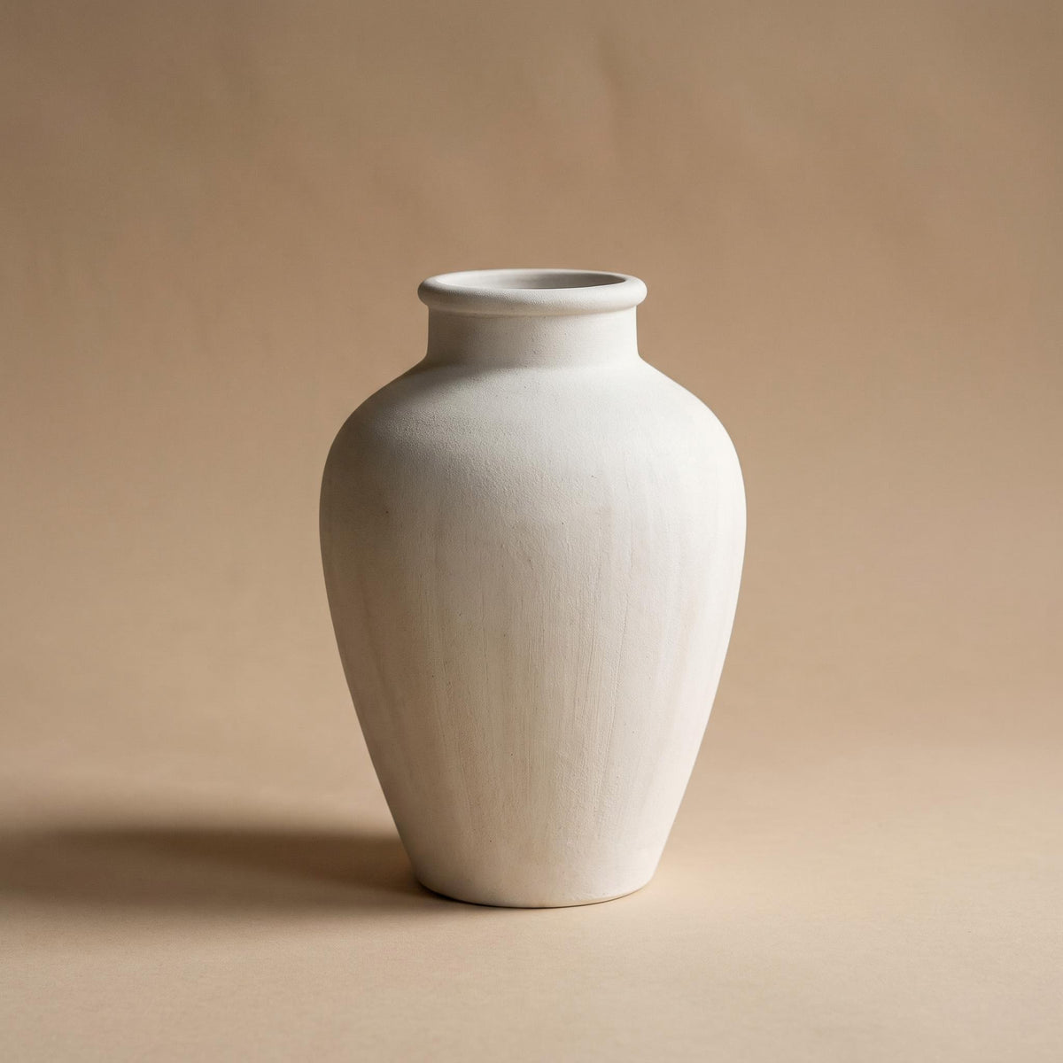 Bianca urn, empty, on a warm neutral background