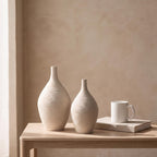 Tall and short Esbel vases next to a coffee mug and a book to show their real size