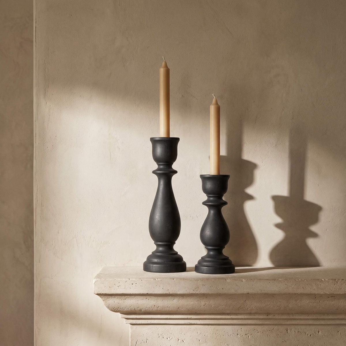 Pilvo holders unlit on a limestone mantelpiece in afternoon light