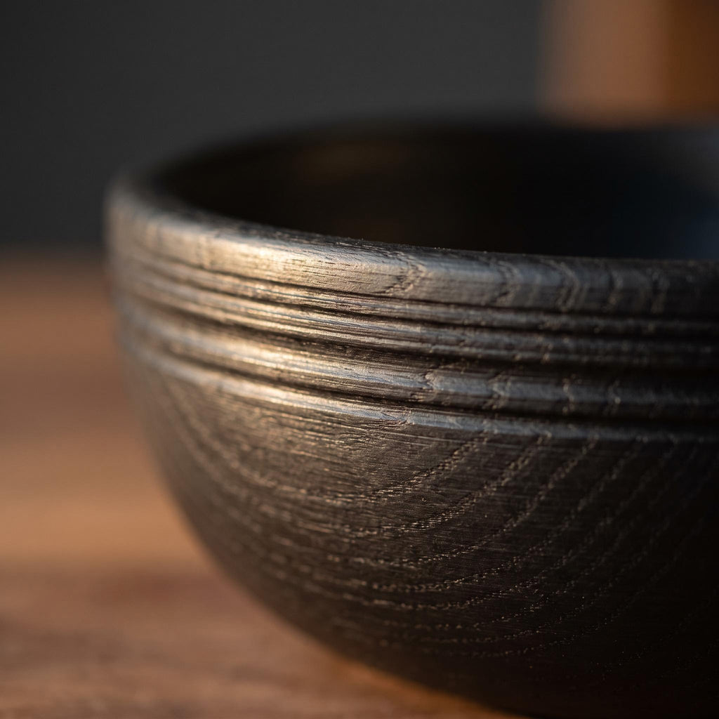 Close-up of the fine ribs and the grain reading through the black finish of the Korren bowl