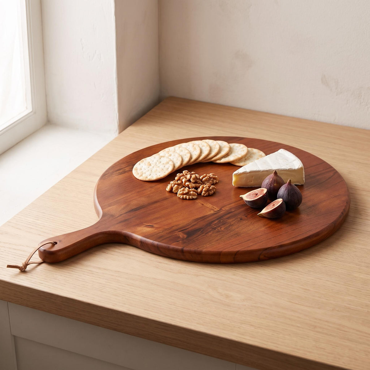 Albo board laid with cheese, crackers, walnuts and figs on a kitchen counter