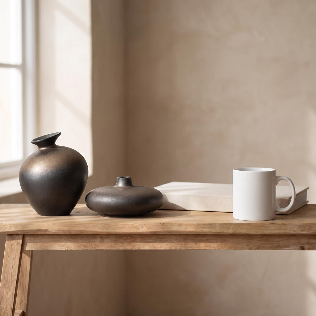 Sumi jar and low bottle next to a coffee mug and a book to show their real size