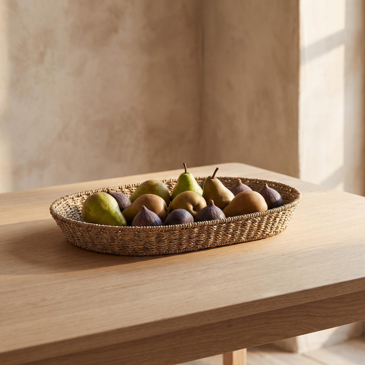 Marea basket on a dining table holding pears and figs in a single layer
