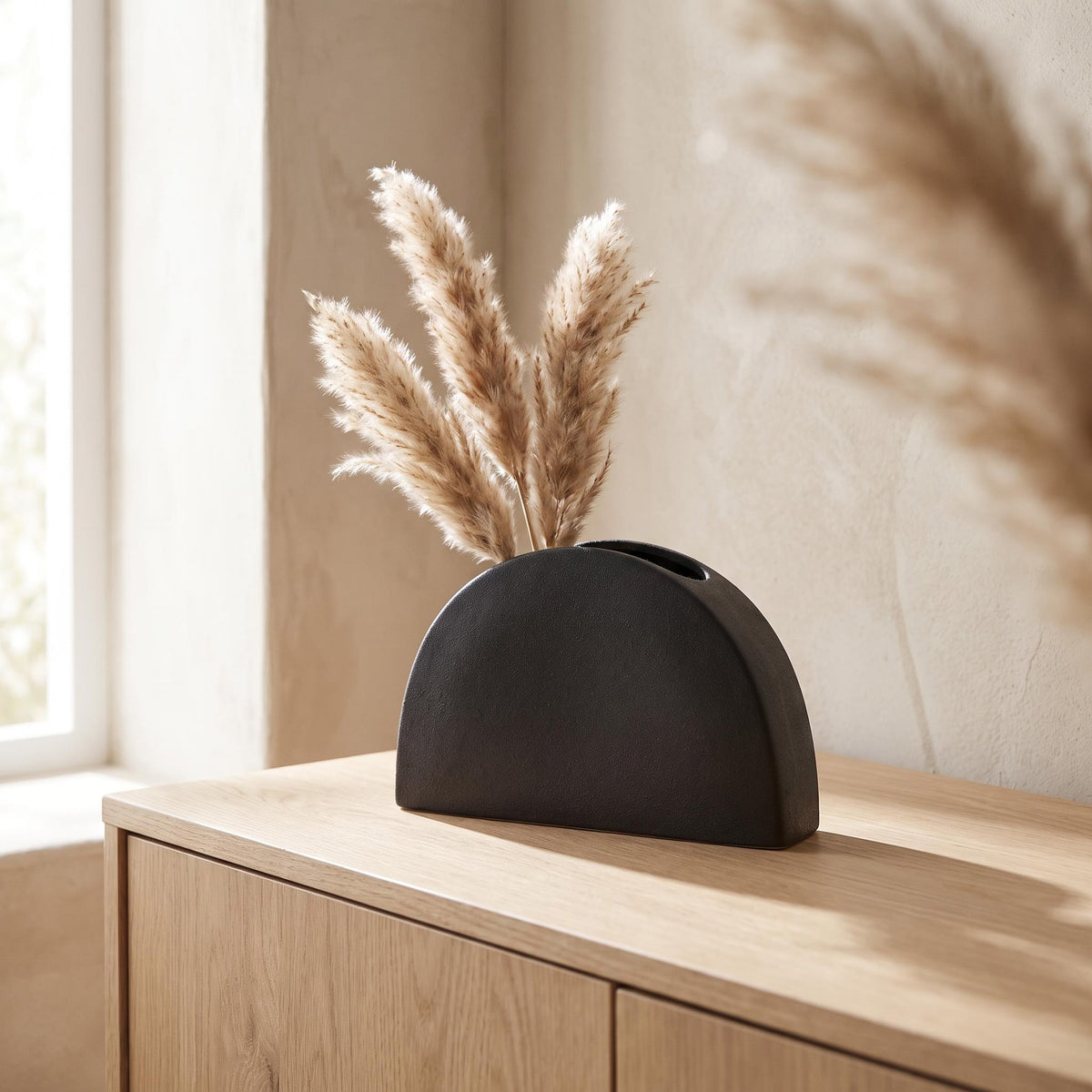 Doven vase on a pale oak sideboard with dried pampas stems in its two openings