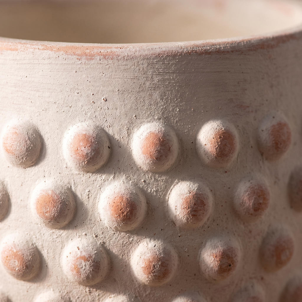 Close-up of the hobnail bumps and terracotta blush under the white limewash