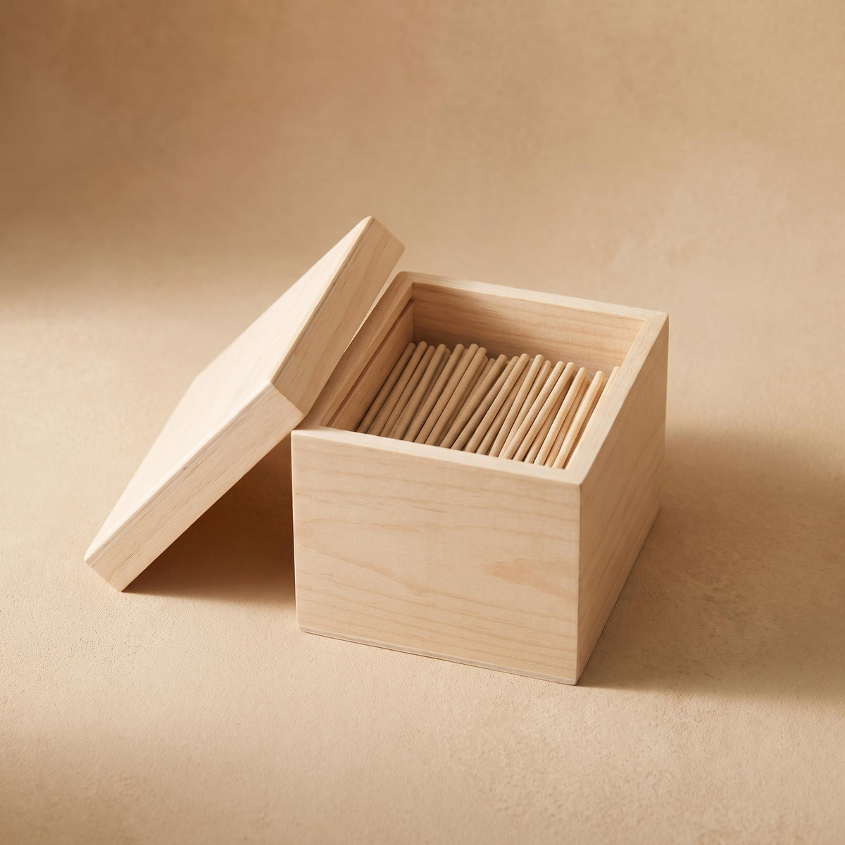 Breve lidded wooden box of short undyed incense sticks, on a warm neutral background