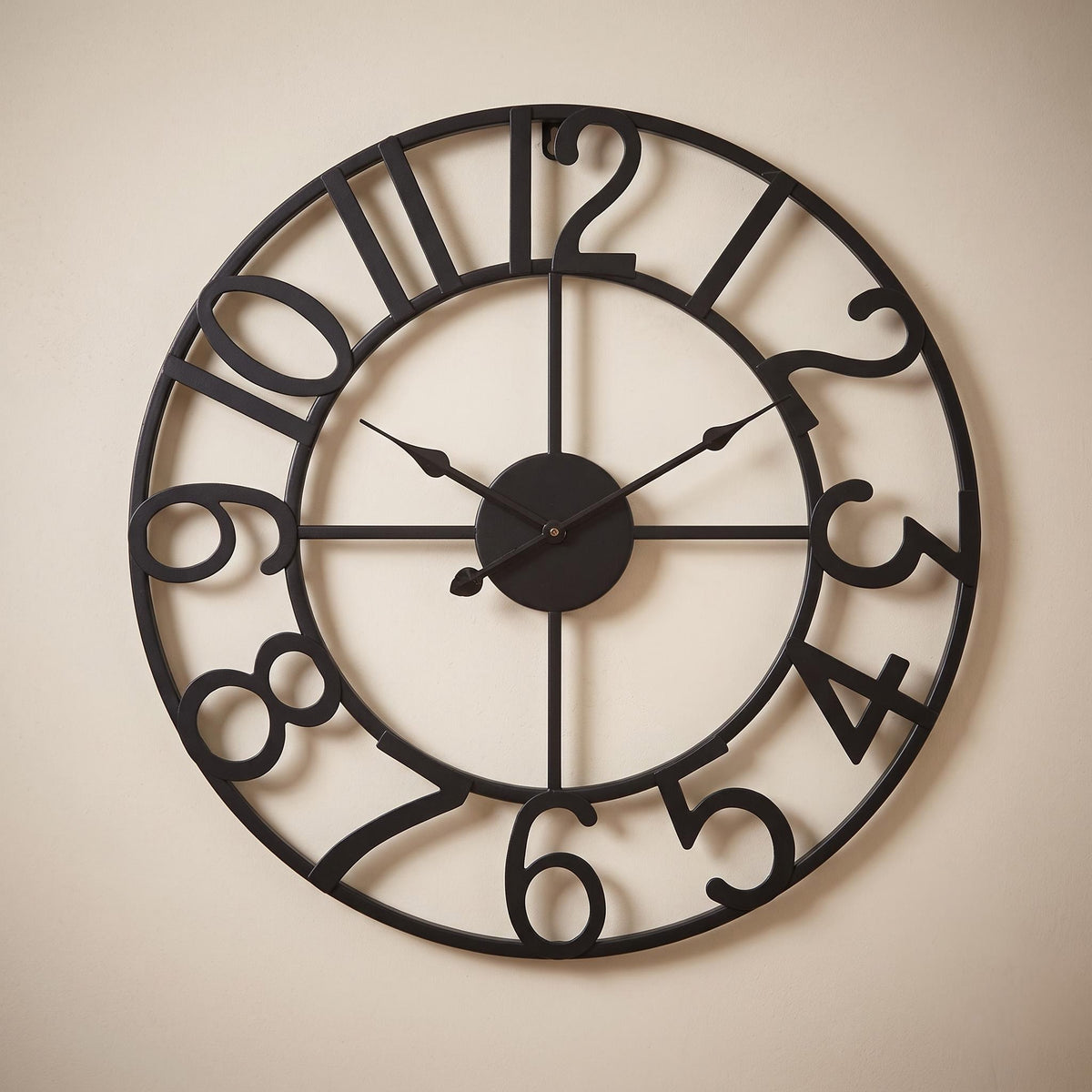 Lunea wall clock in black with dark hands on a warm neutral wall
