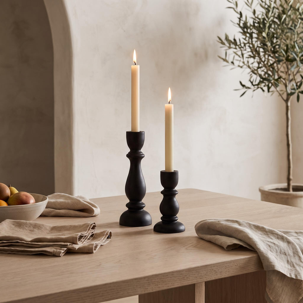 Pilvo holders on a pale oak dining table with two lit cream tapers