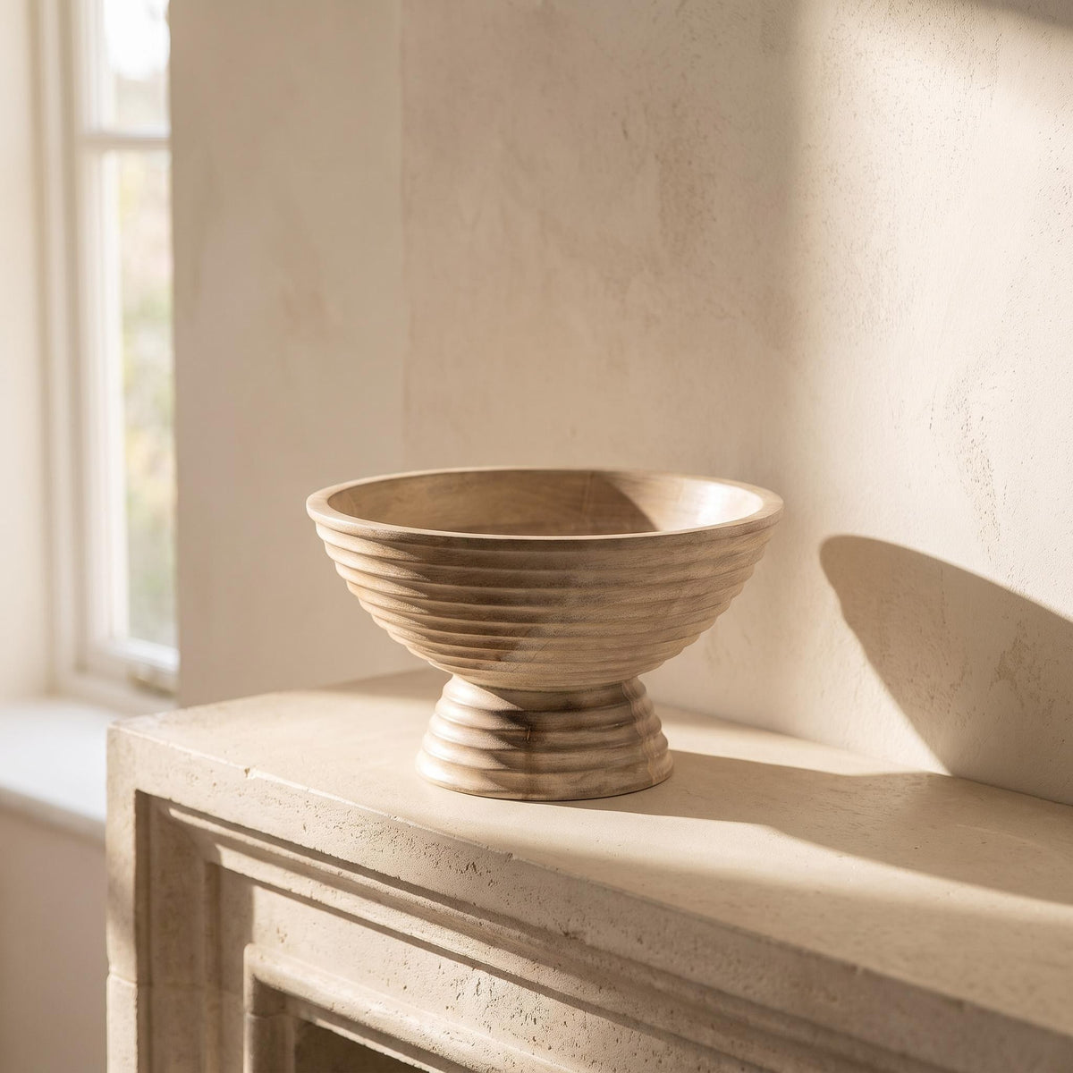 Ormu bowl empty on a limestone mantelpiece in afternoon light