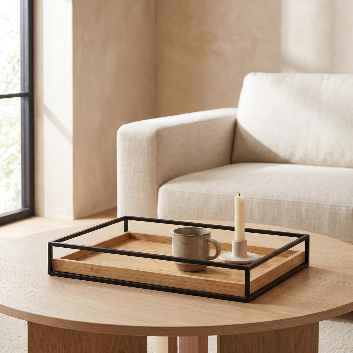 Sável tray on a pale oak coffee table holding a ceramic cup and a candle