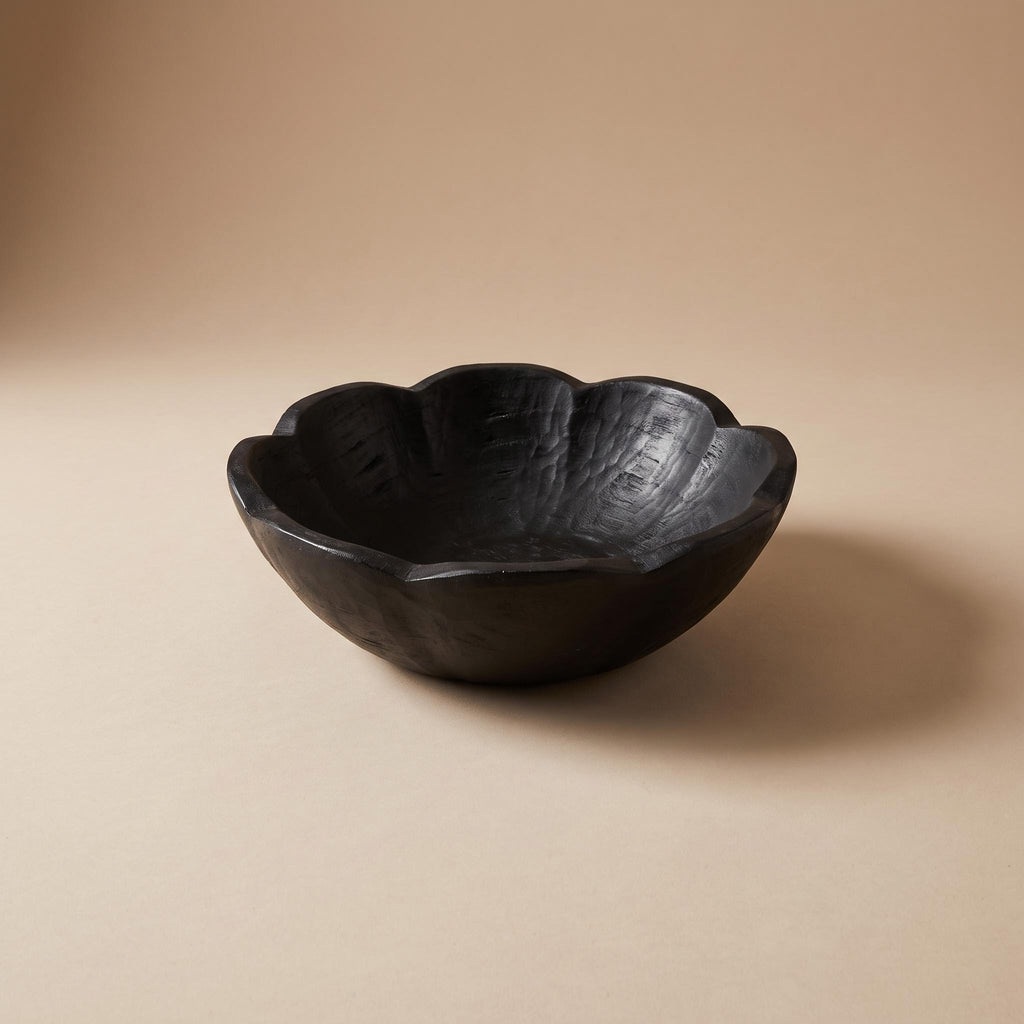 Ondel hand-carved paulownia bowl with a scalloped rim, black, empty, on a warm neutral background