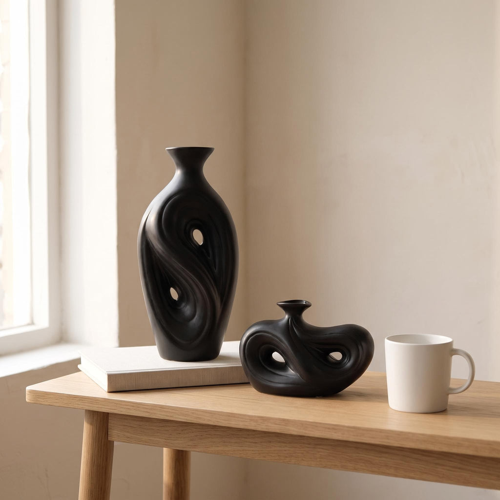 Tall and low Umbra vases next to a coffee mug and a book to show their real size