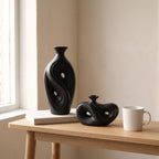 Tall and low Umbra vases next to a coffee mug and a book to show their real size