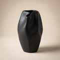 Alven sculptural matte black stoneware vase, empty, on a warm neutral background