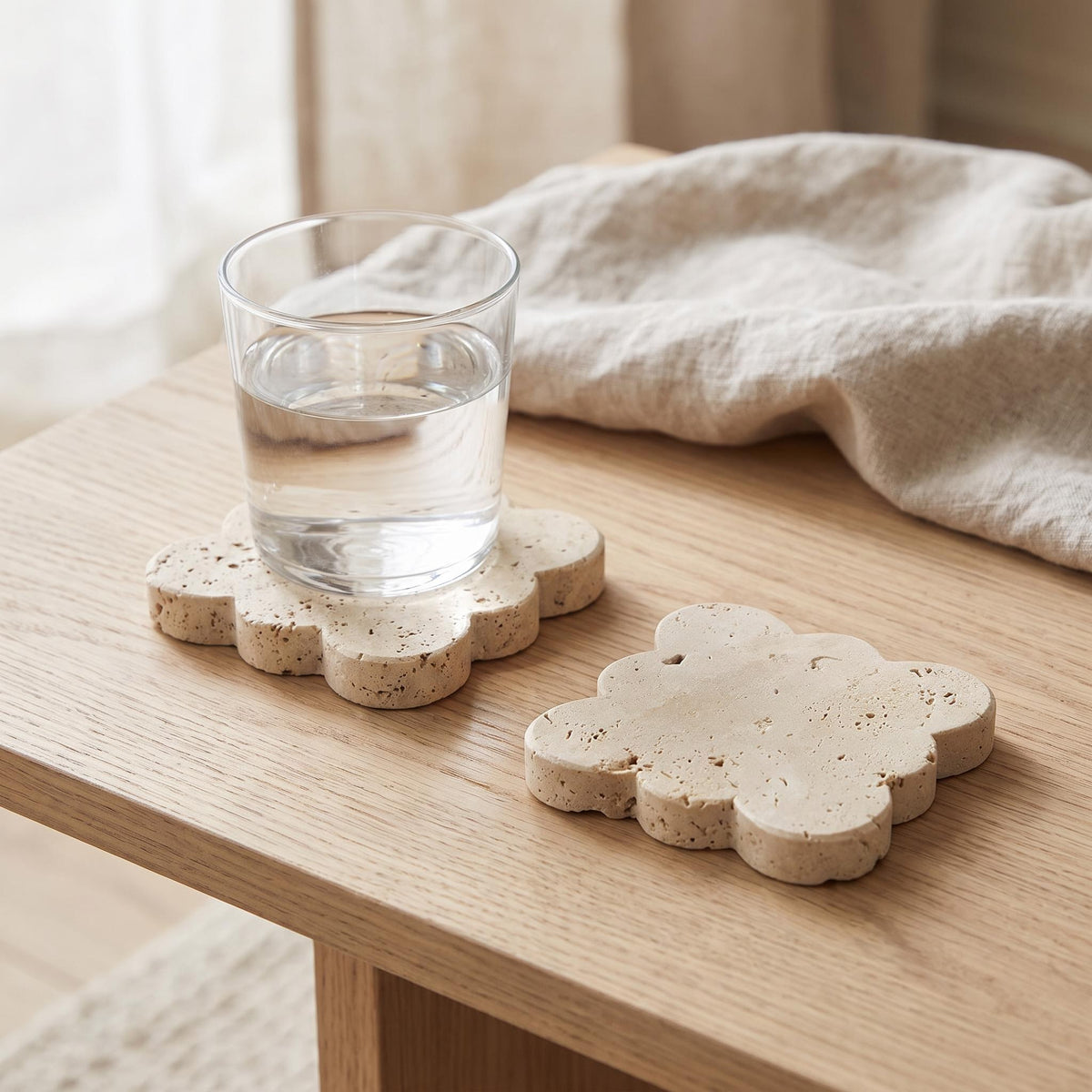 Pietra coaster on a coffee table with a glass standing on it