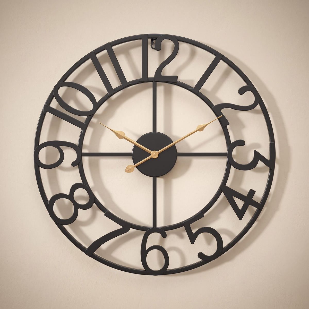 Lunea wall clock in black with gold hands on a warm neutral wall