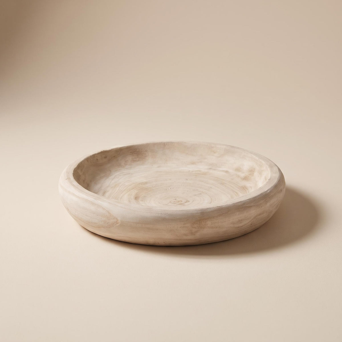 Velto hand-carved paulownia bowl, empty, on a warm neutral background