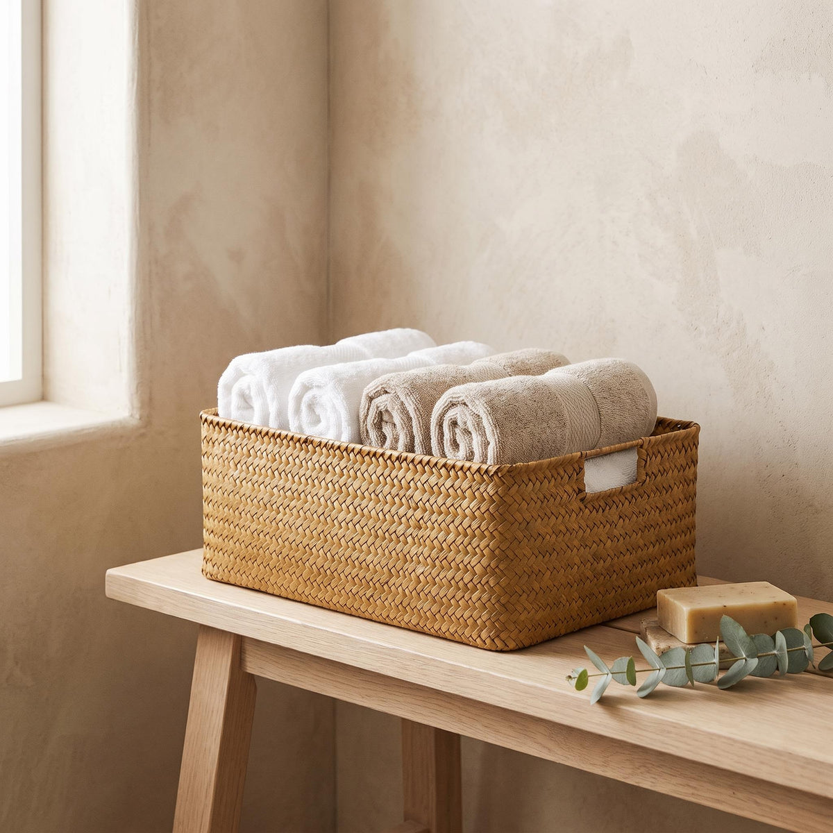 Cesta de junco Junca con toallas enrolladas en un baño tranquilo