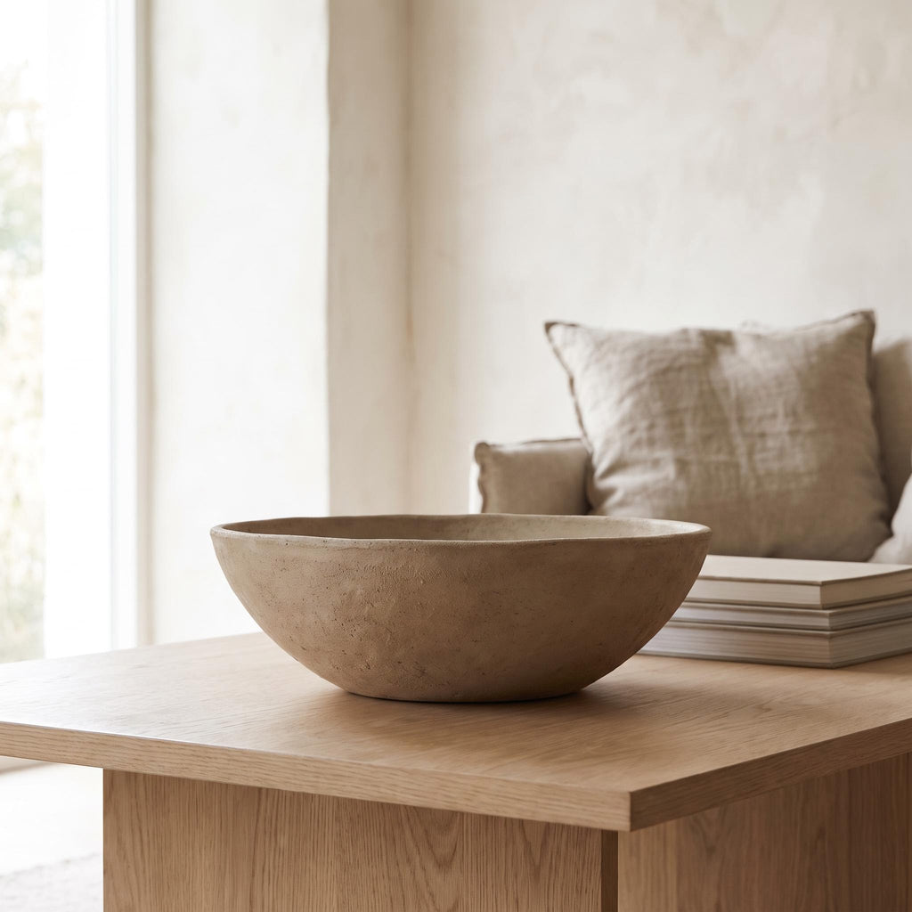 Cálida bowl empty on a pale oak coffee table beside a stack of books