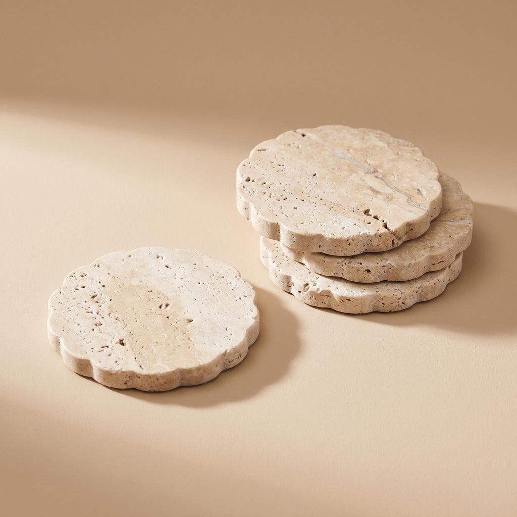 Pietra set of four travertine coasters with a scalloped edge, on a warm neutral background