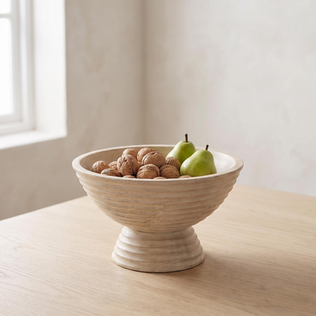 Ormu footed bowl on a dining table holding walnuts and pears