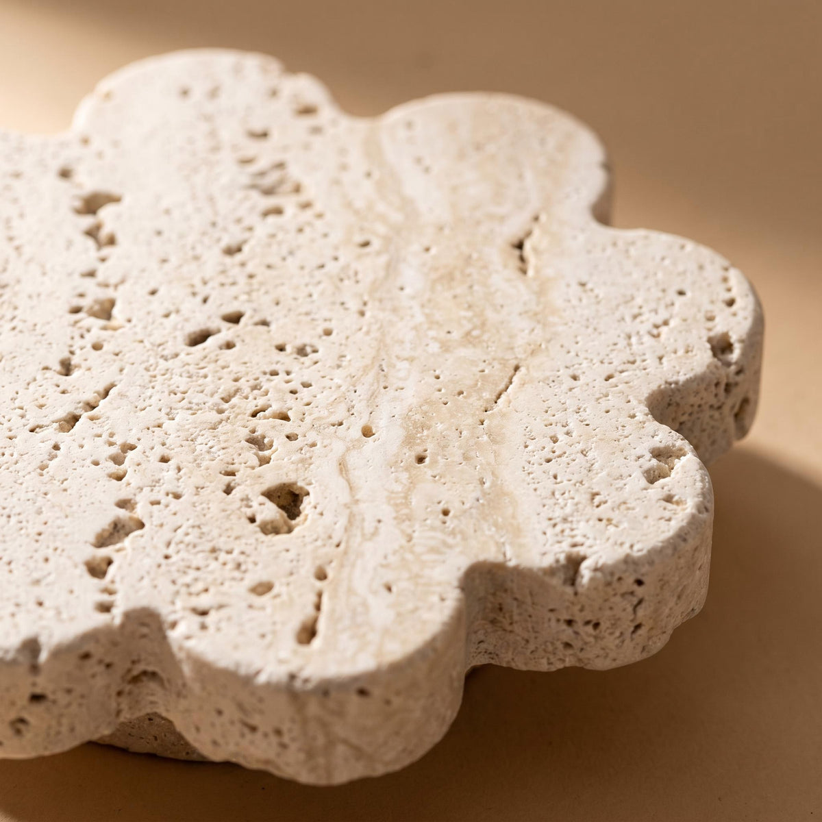 Close-up of the lobed edge and open pores of the Pietra travertine coaster