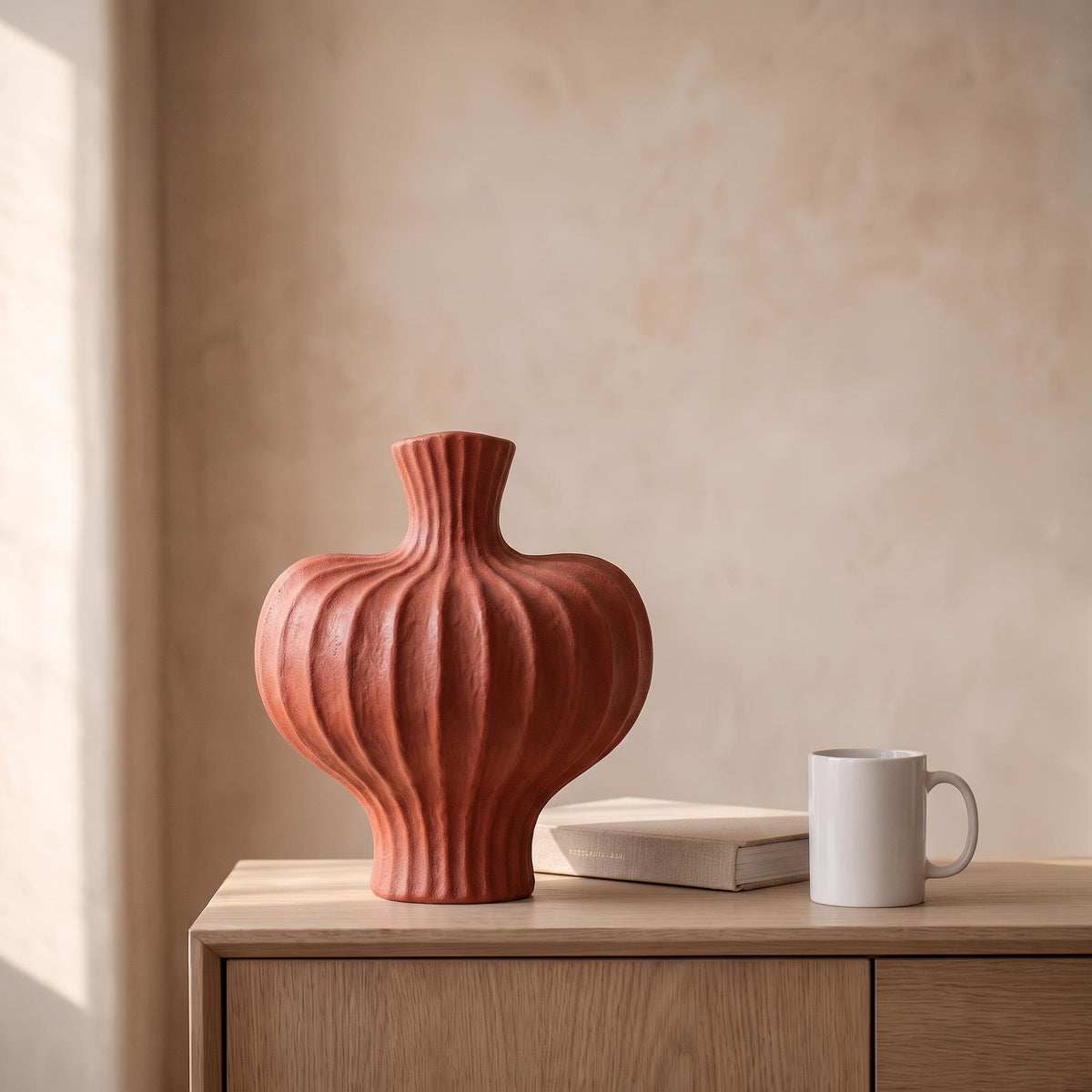 Teja vase next to a coffee mug and a book to show its real size