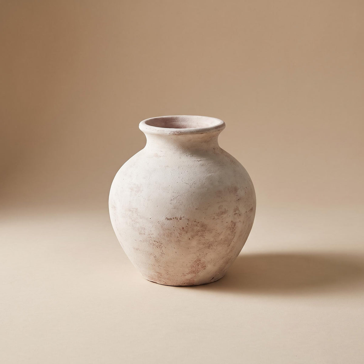 Bianca painted terracotta vase in chalky off-white, empty, on a warm neutral background