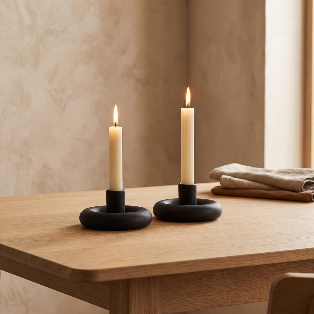 Anel holders on a dining table with two lit cream tapers