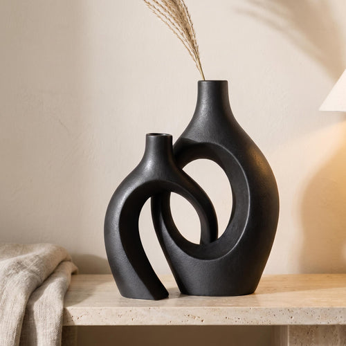 Lazo interlocking ceramic vases in black on a stone shelf